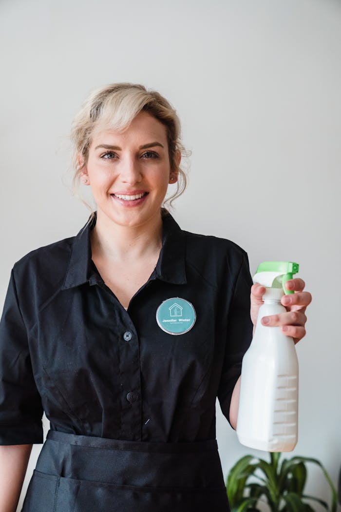 A Smiling Woman Holding a Spray Bottle